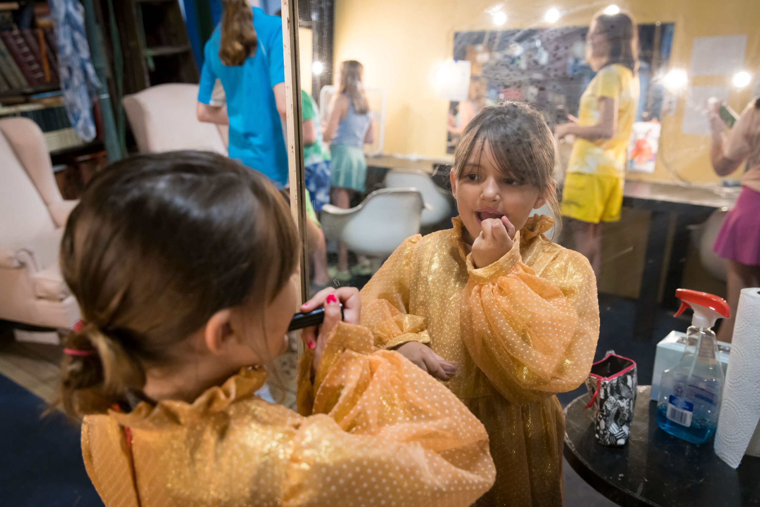 A child performing in Cape Cod Theatre Company's production of "Finding Nemo" puts on makeup backstage before a show.